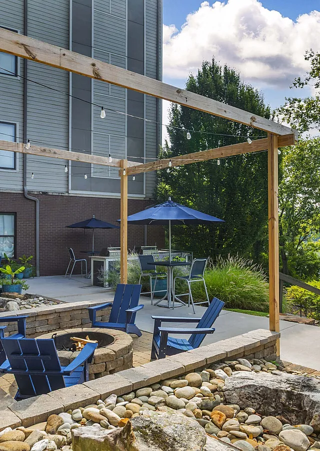 Stylish outdoor patio with blue Adirondack chairs and fire pit for resident gatherings at The Landings Knoxville TN