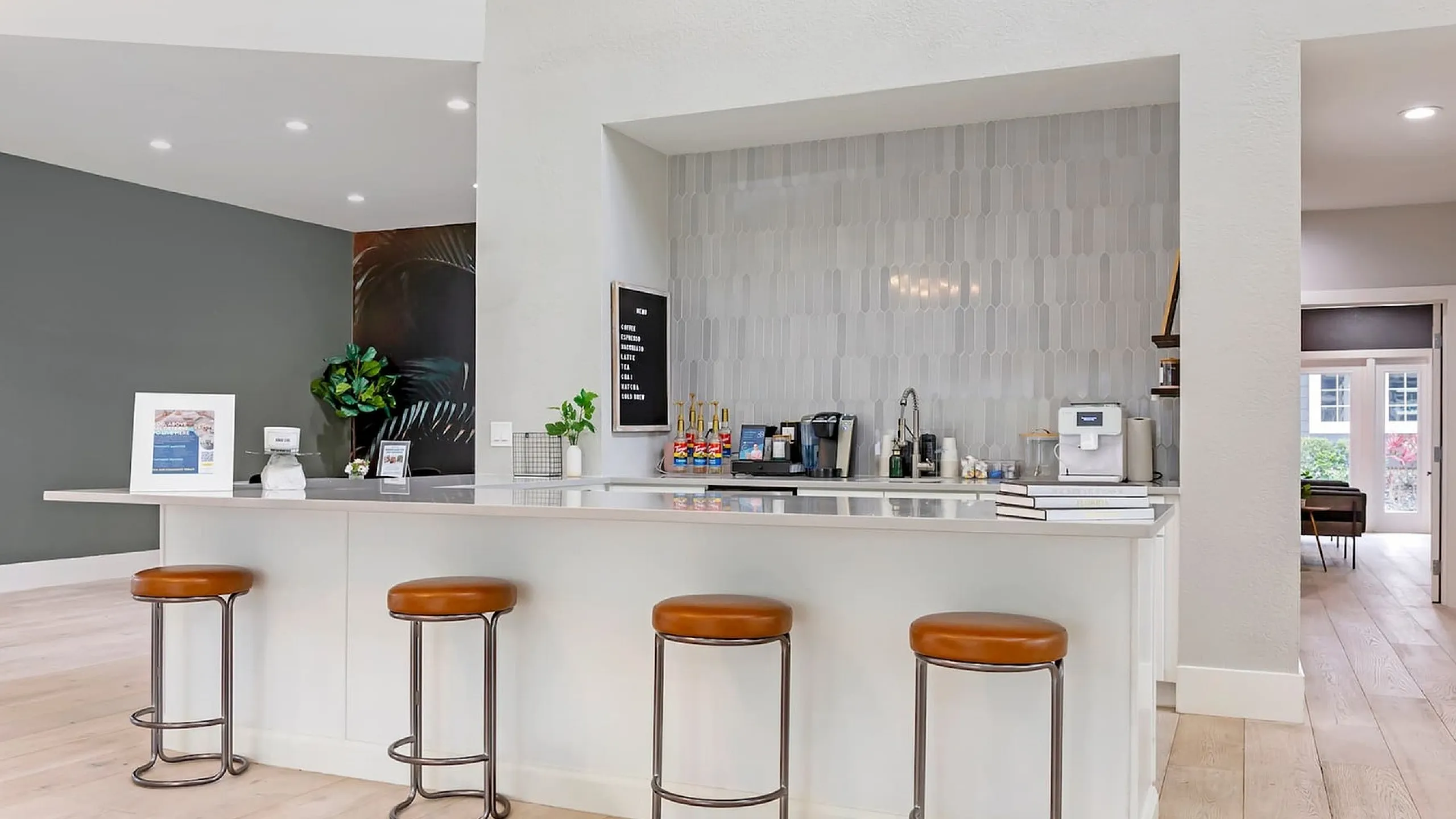 Phoenix Orlando community lounge and kitchen with sleek countertops, stylish bar stools, and warm lighting, exuding a cozy and inviting atmosphere.