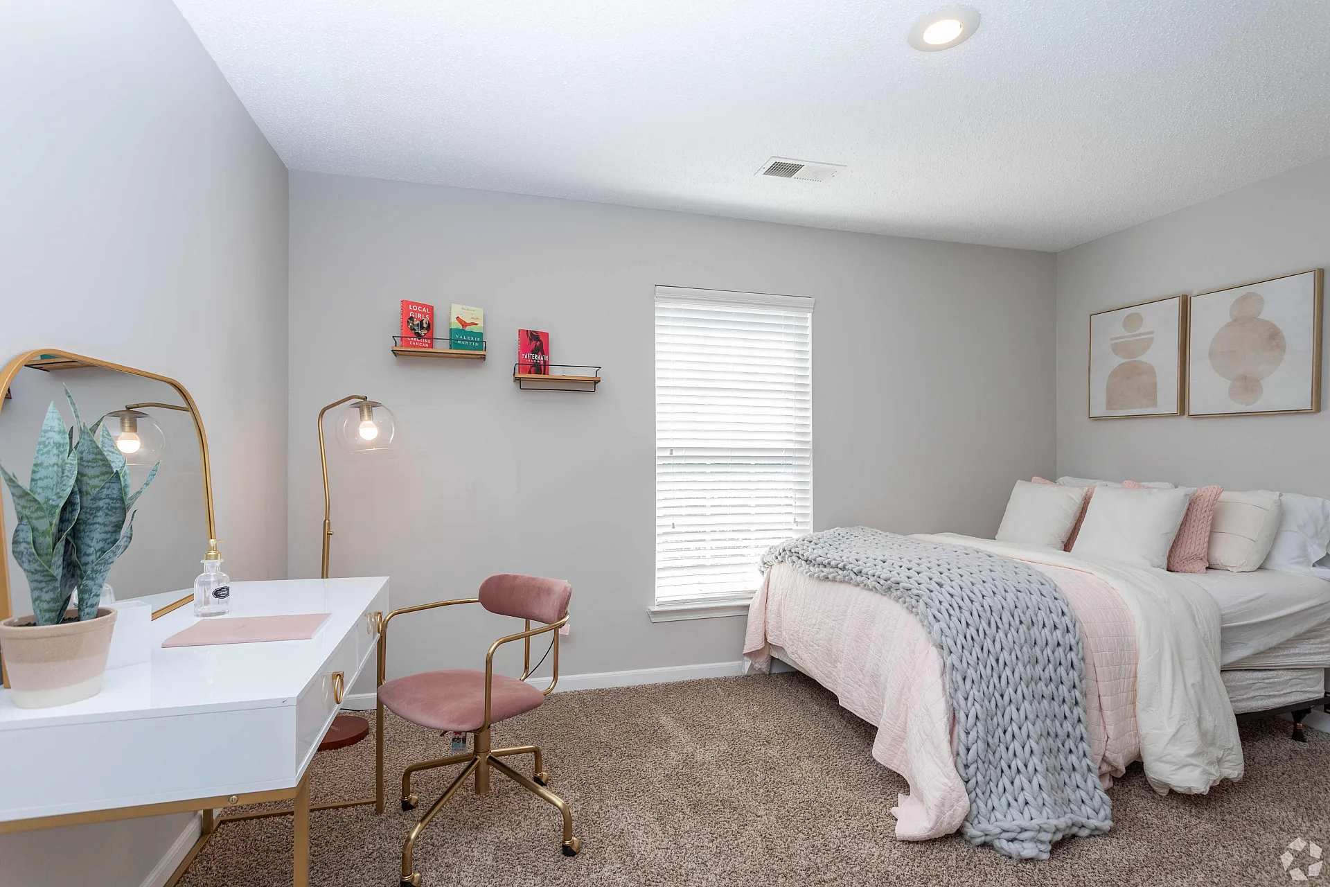 Chic bedroom with stylish decor, featuring a cozy bed, elegant vanity, and modern wall art, bathed in natural light.