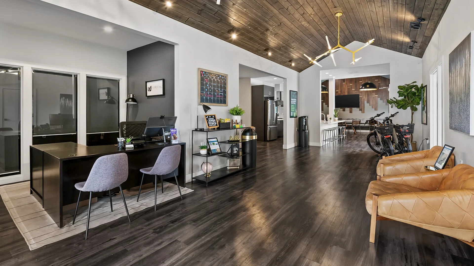 Modern interior space featuring a stylish office area, sleek wooden ceiling, and inviting seating with contemporary lighting.