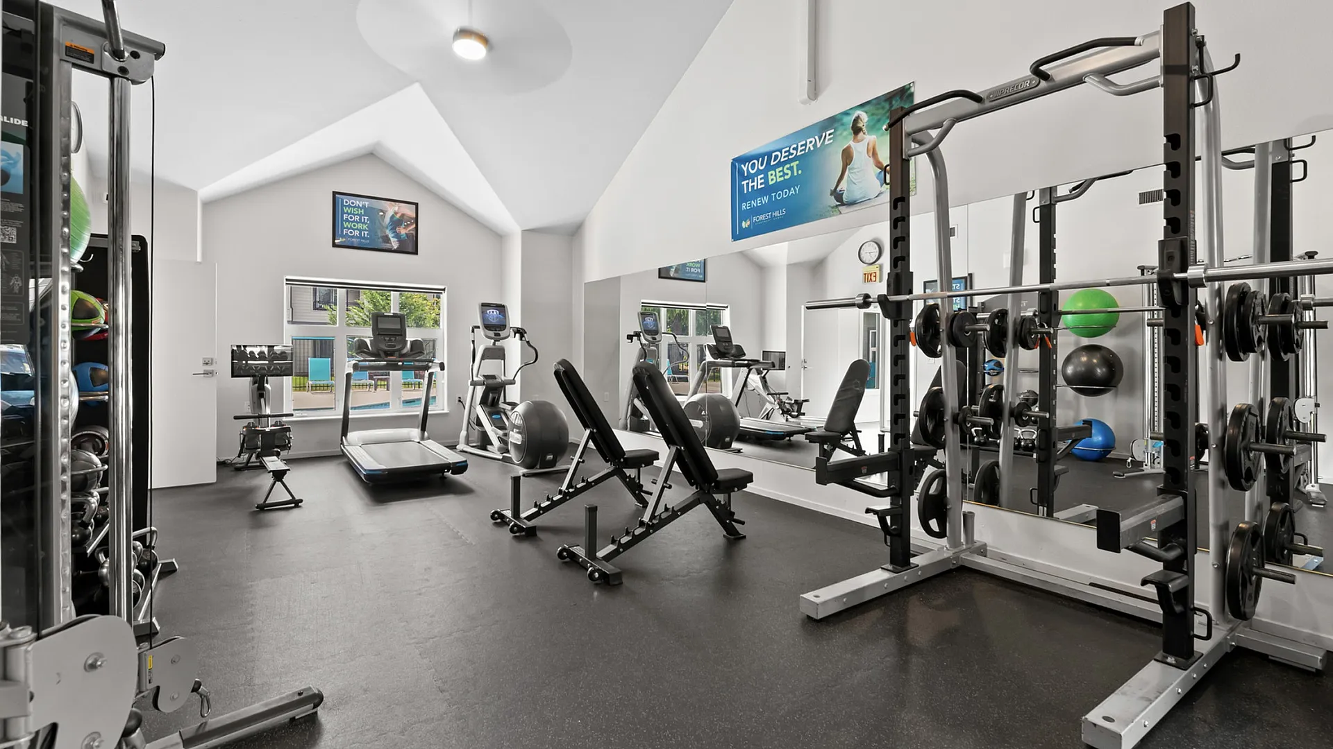 Modern and spacious gym with high ceilings, featuring state-of-the-art exercise equipment, weight racks, and cardio machines, perfect for a dynamic workout experience.