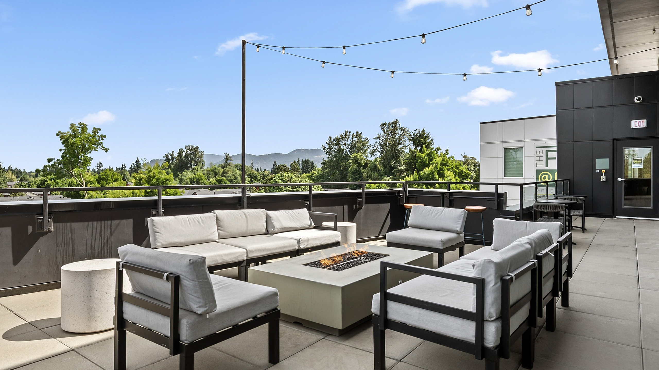 Chic outdoor terrace with cozy seating, a stylish fire pit, and stunning mountain views, ideal for relaxation and gatherings.