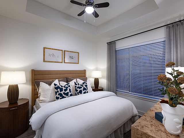 Cozy bedroom with a plush bed, elegant nightstands, soft lighting, and tasteful decor, perfect for relaxation and comfort.