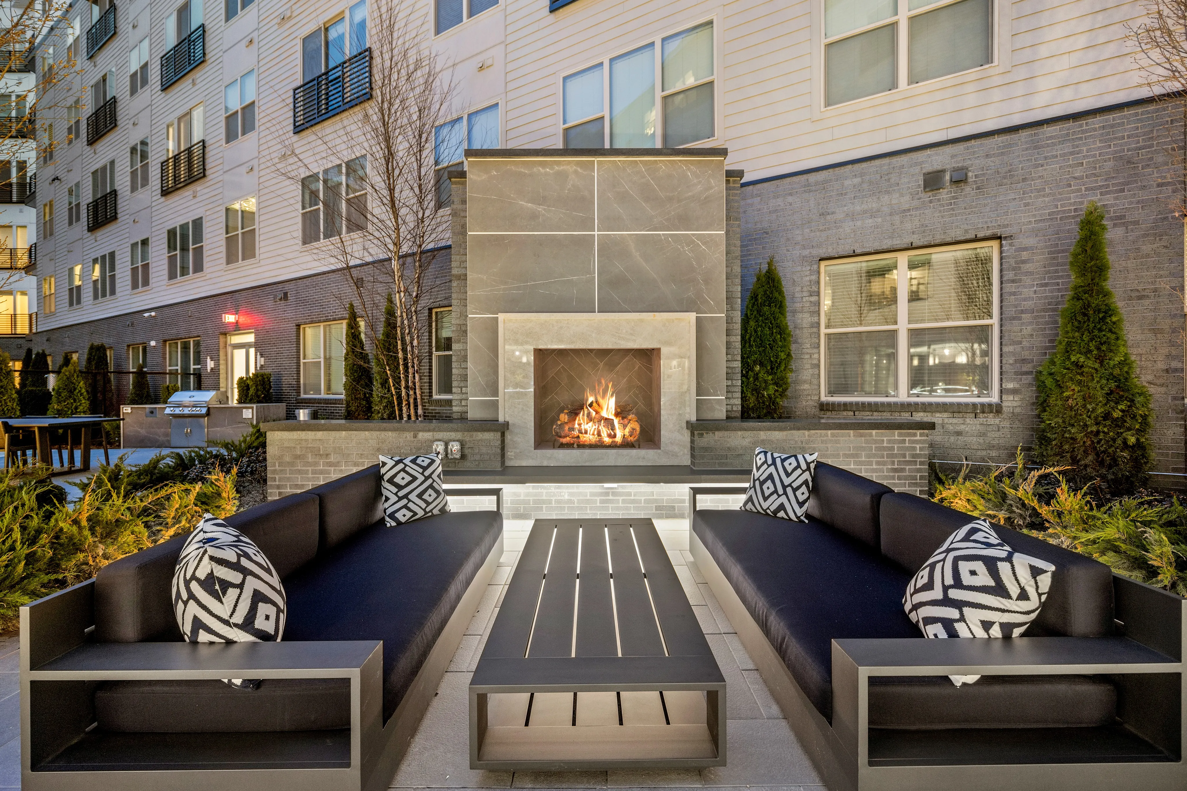 Three unique courtyards featuring an outdoor pool table, fireplaces surrounded by intimate seating and grills with open-air dining