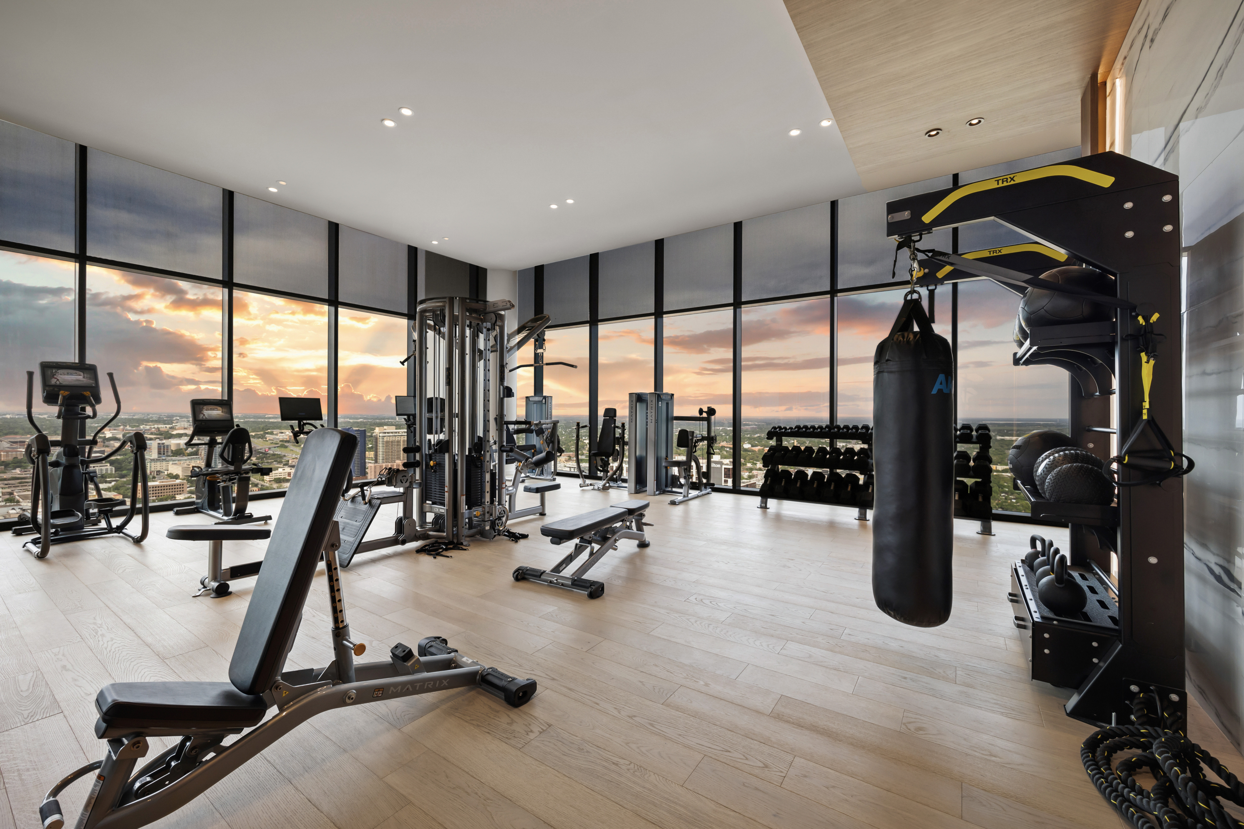 Luxury fitness center with modern equipment and panoramic city views, featuring a spacious layout for optimal workouts.