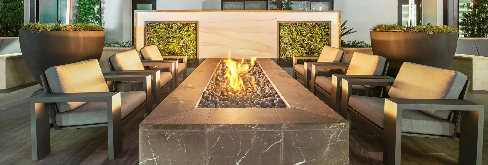 black rectangle marble firepit with 6 chairs and accent wall