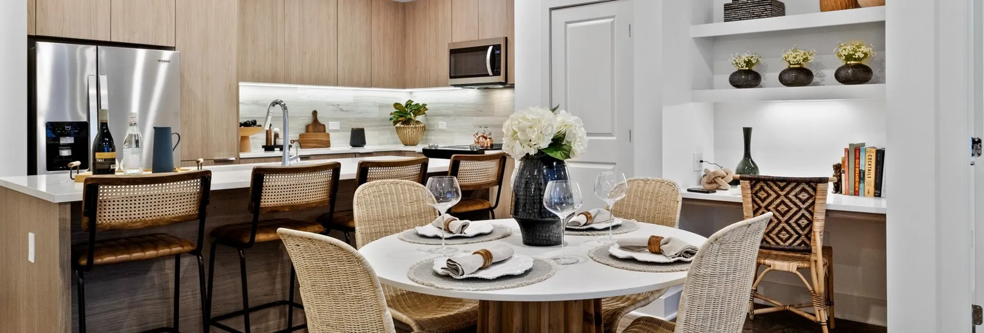kitchen with beige wood cabinets and white counter top with dining table and built in desk