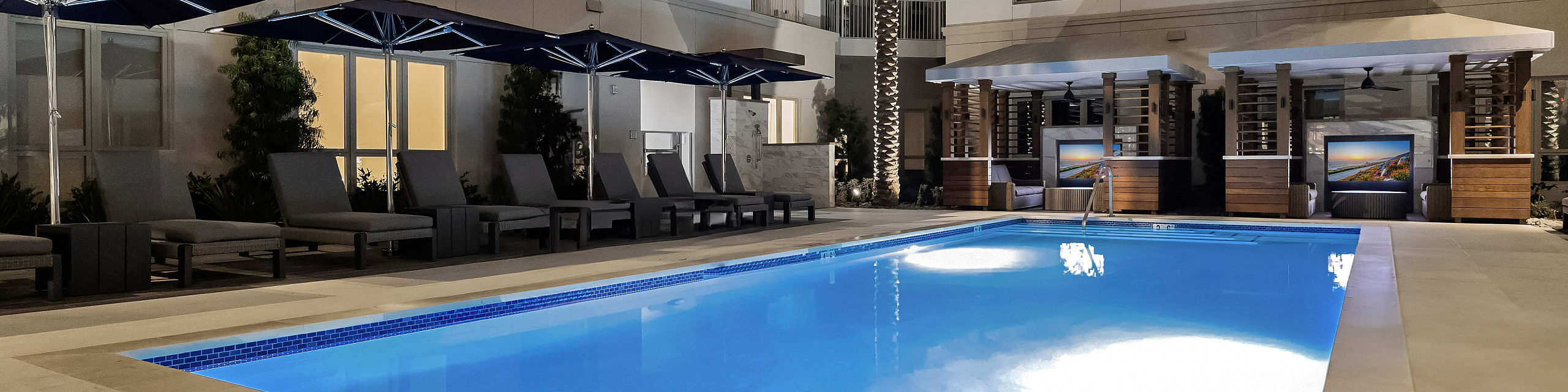 pool with chaise lounge seating and cabanas