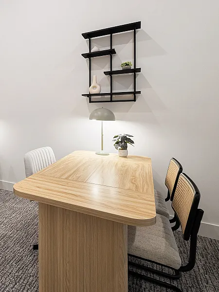 Sleek and modern workspace with wooden tables, contemporary chairs, and decorative shelving.