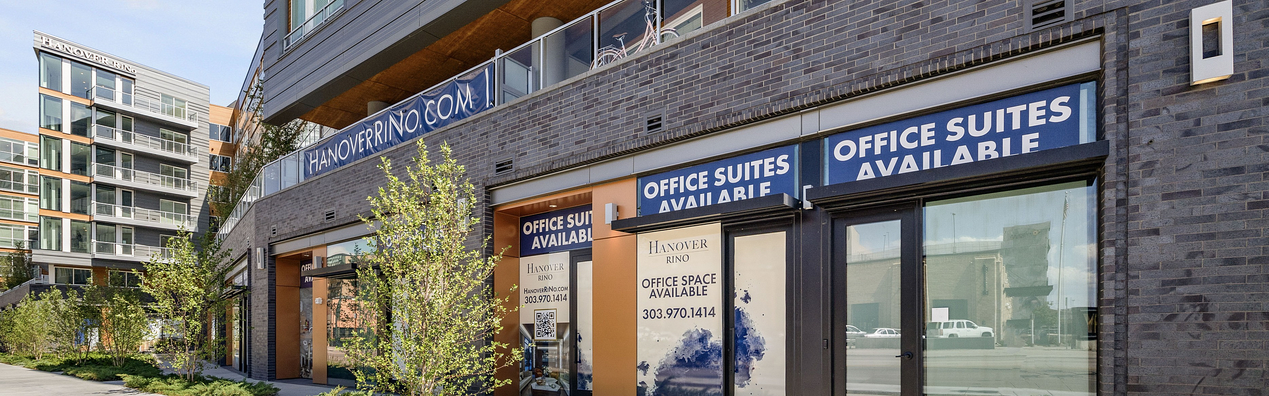 Modern building facade with office suites available, featuring sleek architecture and large windows.
