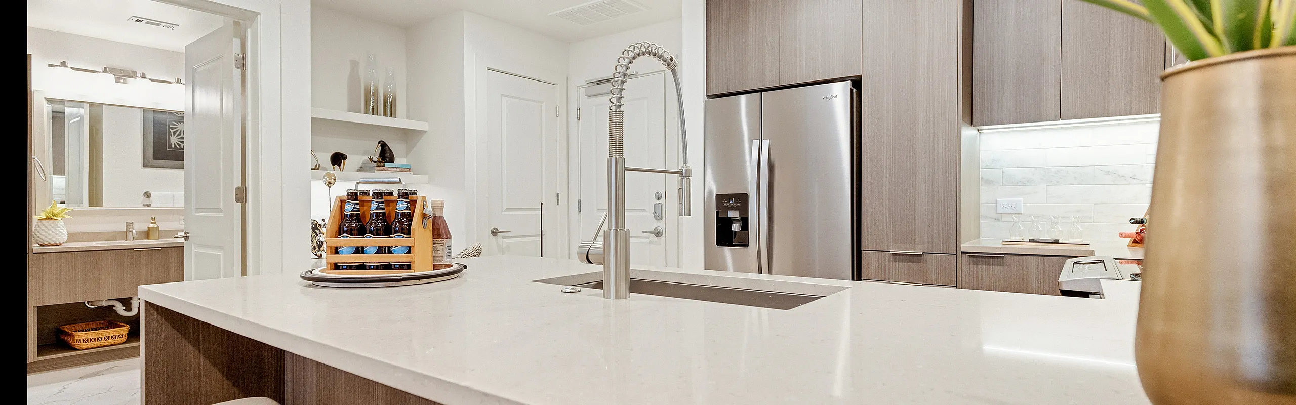 Elegant modern kitchen with sleek countertops, stainless steel appliances, and stylish seating. Bright and inviting space with open shelving and contemporary decor accents.