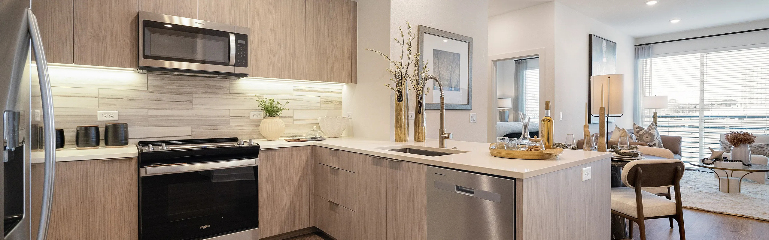 Modern apartment featuring a stylish kitchen with stainless steel appliances and a bright, open-concept living room.