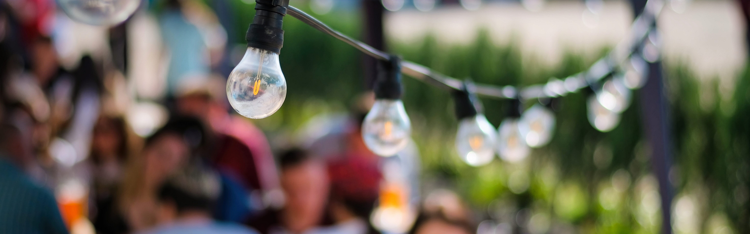Charming outdoor gathering beneath a canopy of string lights, creating a warm and inviting atmosphere for social events.