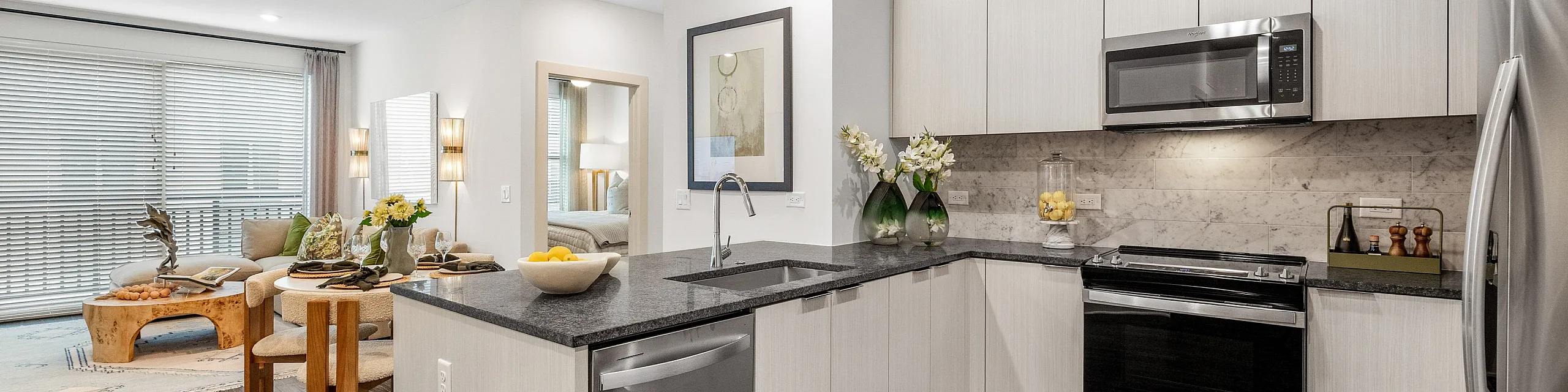 Modern open-plan kitchen and living area with sleek cabinetry, stainless steel appliances, and elegant decor for a luxurious living experience.