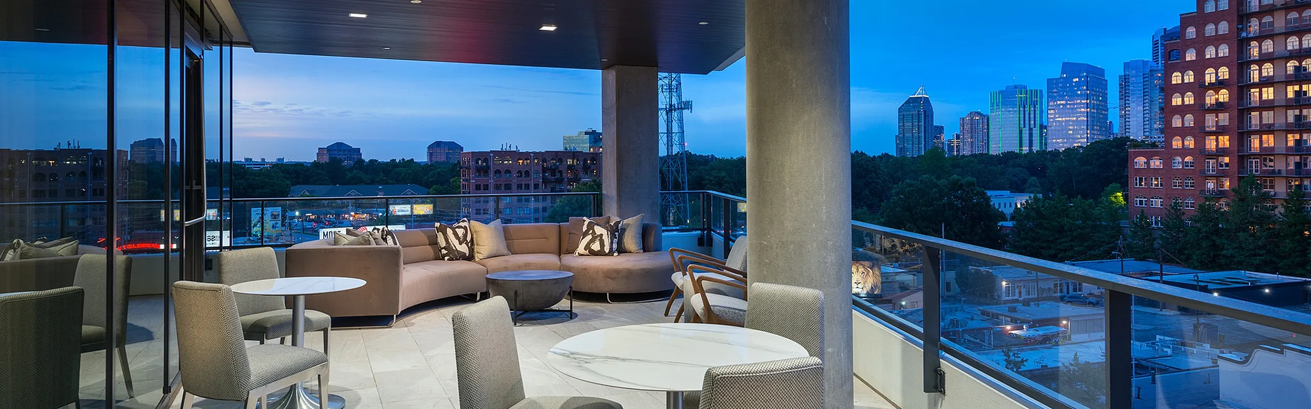 Luxurious rooftop terrace offering elegant seating and breathtaking cityscape views at dusk.
