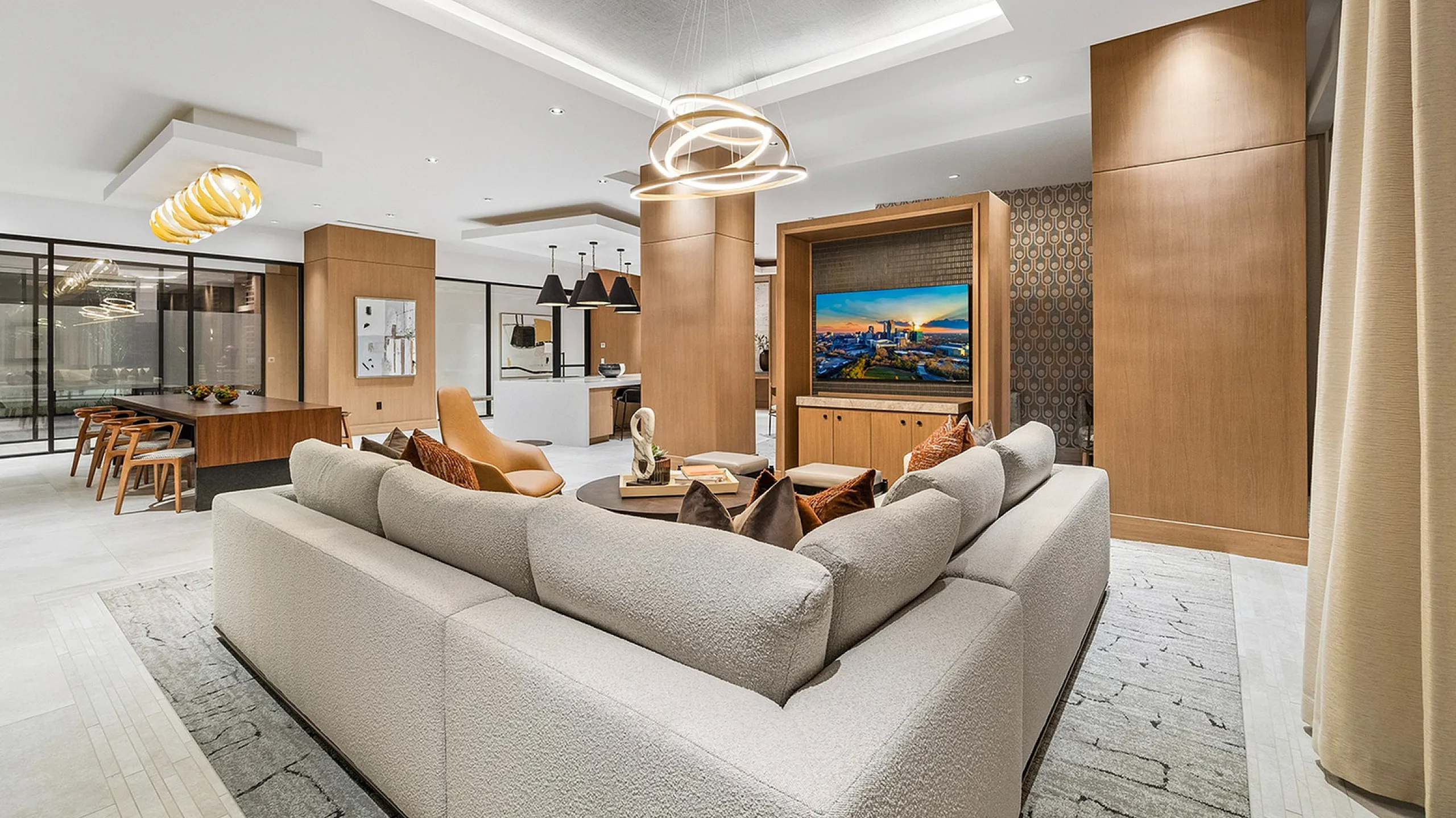 Luxurious open-concept living room with elegant sectional sofa, modern lighting fixtures, and stylish wooden accents, perfect for sophisticated relaxation.