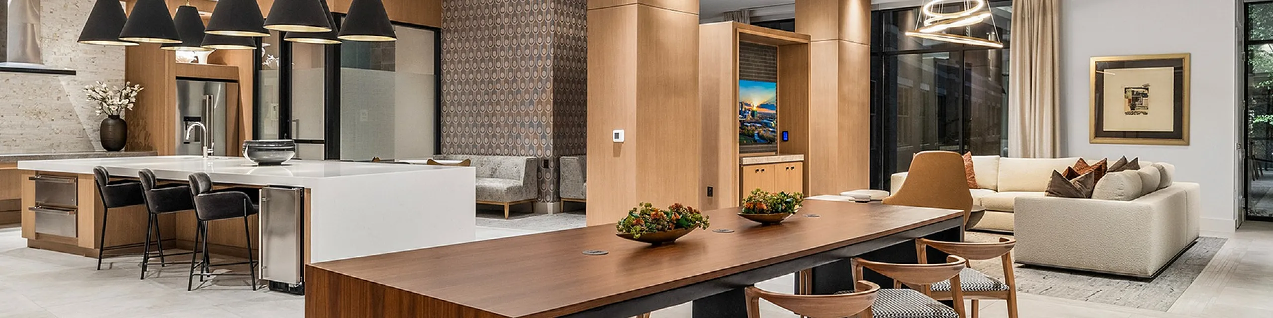 Modern open-concept living space featuring a chic kitchen with island seating, elegant dining area, and cozy living room with stylish decor and large windows.