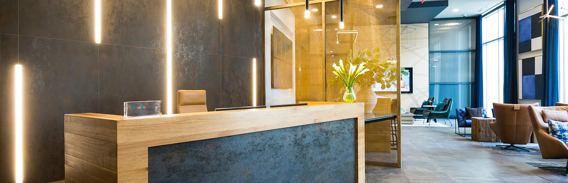 Luxurious modern lobby with sleek wooden reception desk, elegant lighting, and comfortable seating area.