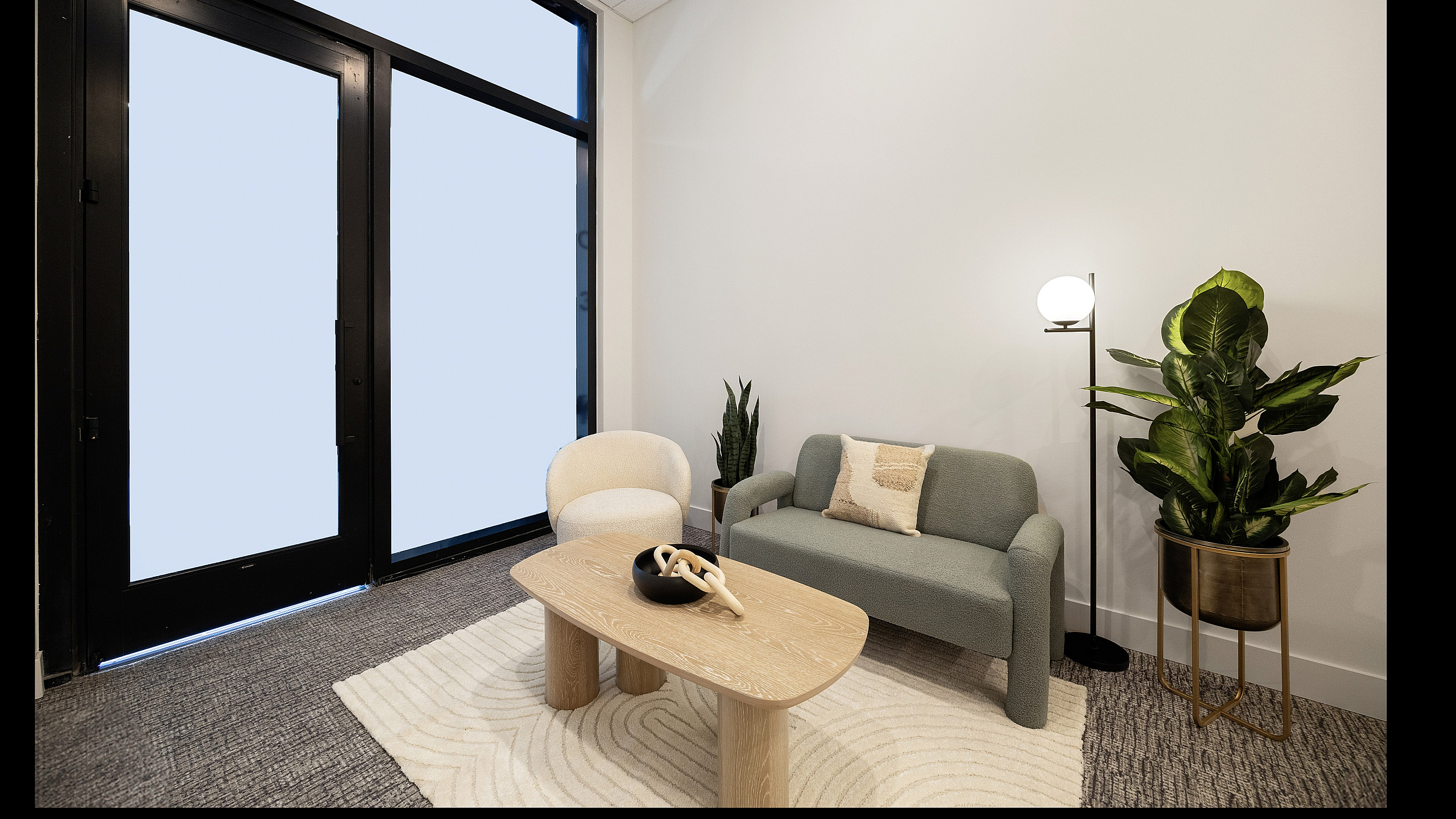 Chic and modern living room with a cozy sofa, elegant armchair, stylish wooden coffee table, and lush potted plants, showcasing contemporary design.