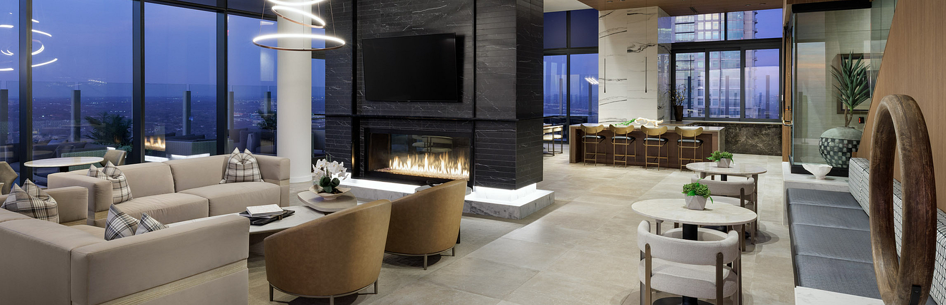 Luxurious open-concept living space featuring elegant seating, modern lighting, and stunning panoramic city views.