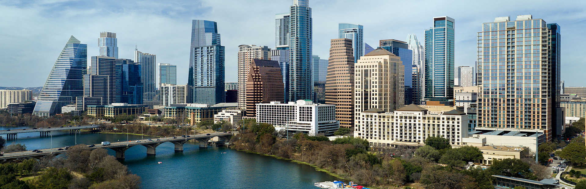 Breathtaking city skyline view with modern skyscrapers along a tranquil river, perfect for urban living enthusiasts.