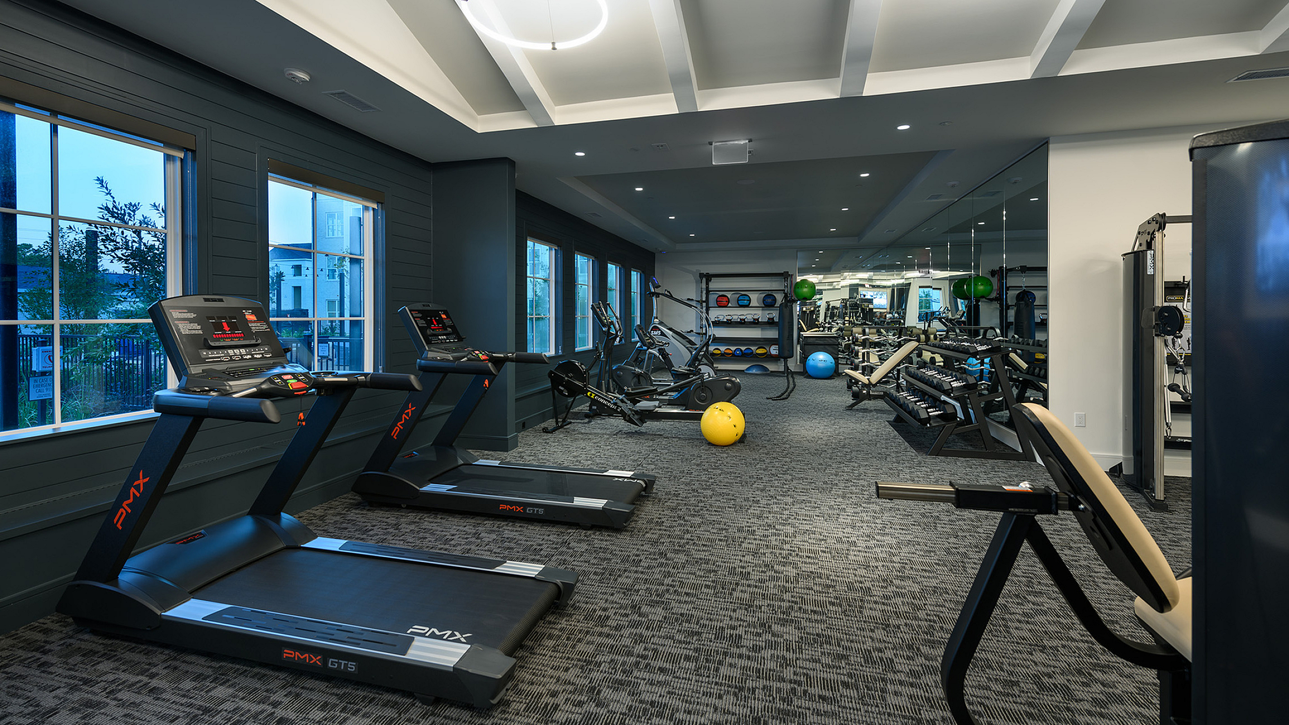 Modern fitness center with state-of-the-art treadmills, exercise bikes, and vibrant workout equipment, offering a sleek and energized workout environment.
