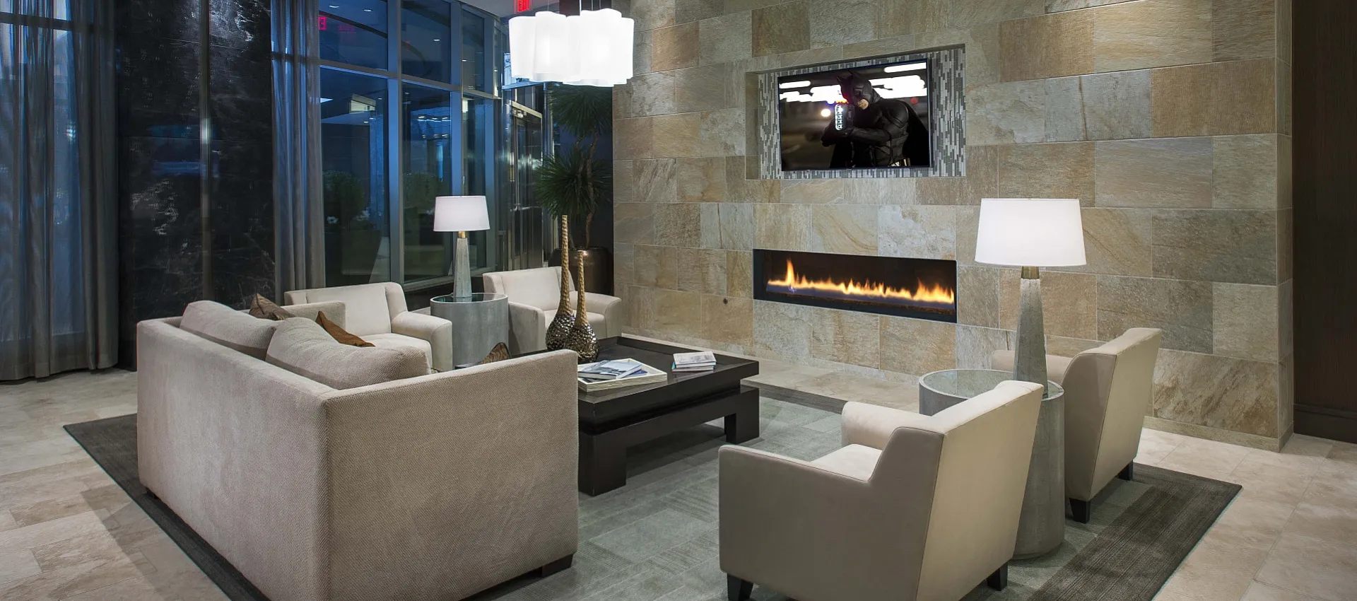 Luxurious modern lounge with elegant beige seating, ambient fireplace, and sophisticated decor in a stylish apartment setting.