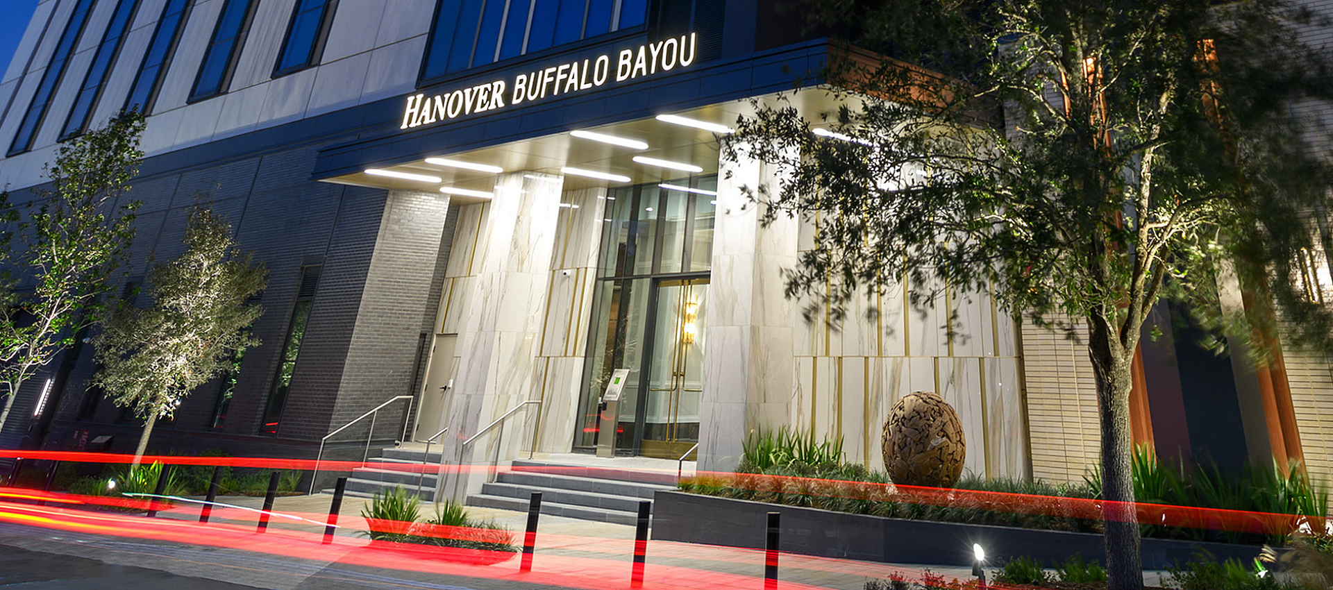 Stunning high-rise building at dusk with modern architecture and illuminated entrance, ideal for urban living.