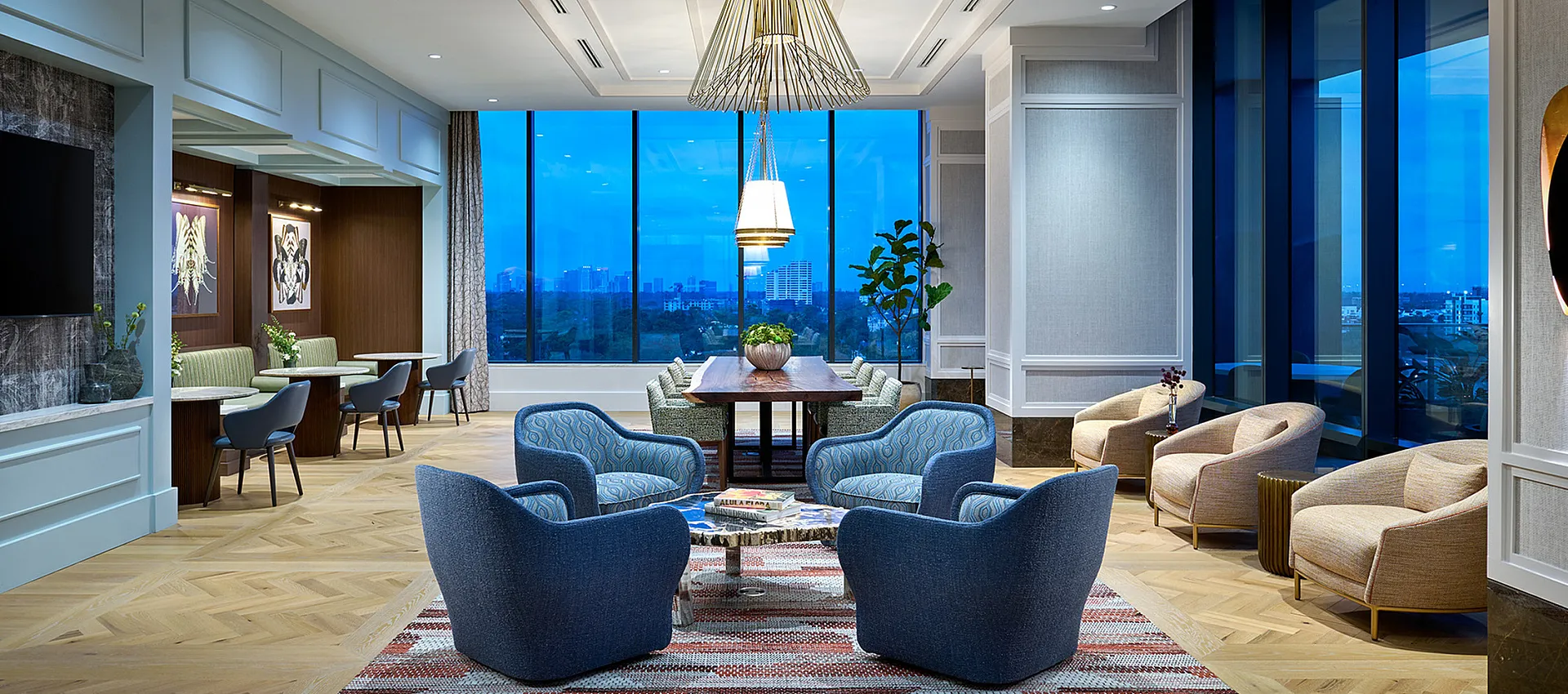Elegant lounge area with modern furniture, large windows offering stunning city views, and stylish lighting fixtures.