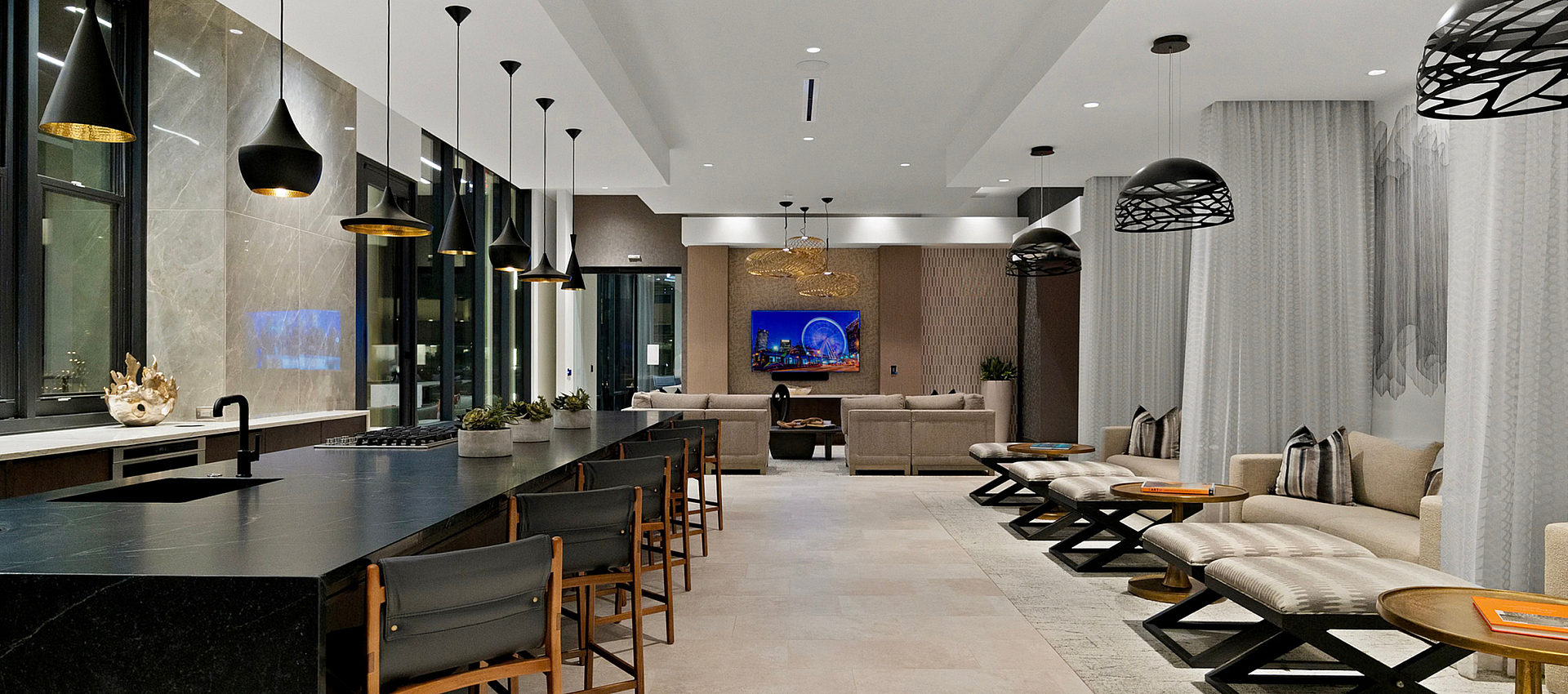 Elegant open-concept lounge with modern pendant lights, sleek seating, and a luxurious marble counter.