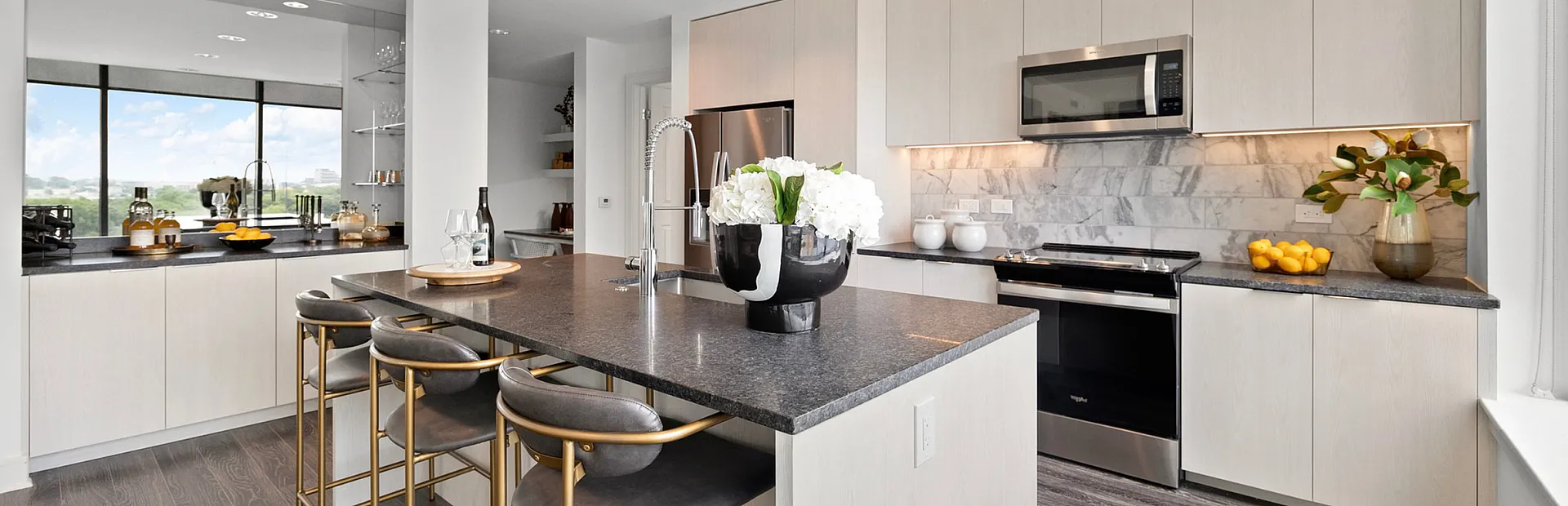 Modern kitchen with sleek appliances, elegant countertops, and stylish bar seating, perfect for entertaining.