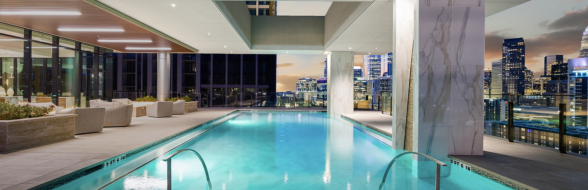 Luxurious rooftop infinity pool with stunning city skyline views, elegant lounge area, and ambient lighting for a premium urban living experience.