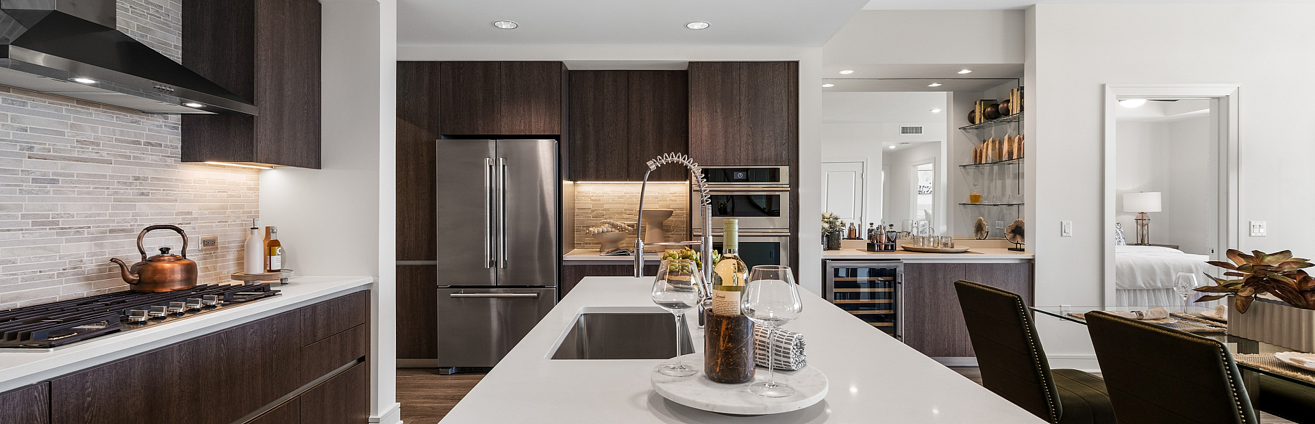 Luxurious open-concept kitchen with sleek cabinetry, modern appliances, and elegant dining area, perfect for stylish living.