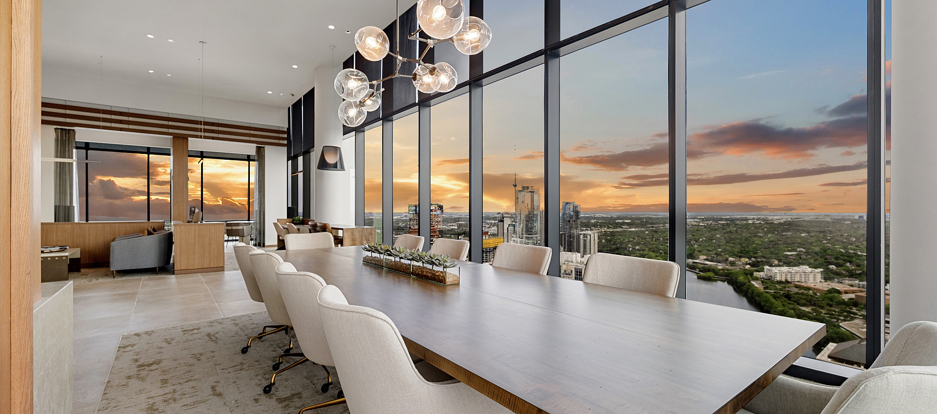 Luxurious dining area with stunning city skyline views through floor-to-ceiling windows, showcasing a modern chandelier and elegant furnishings.