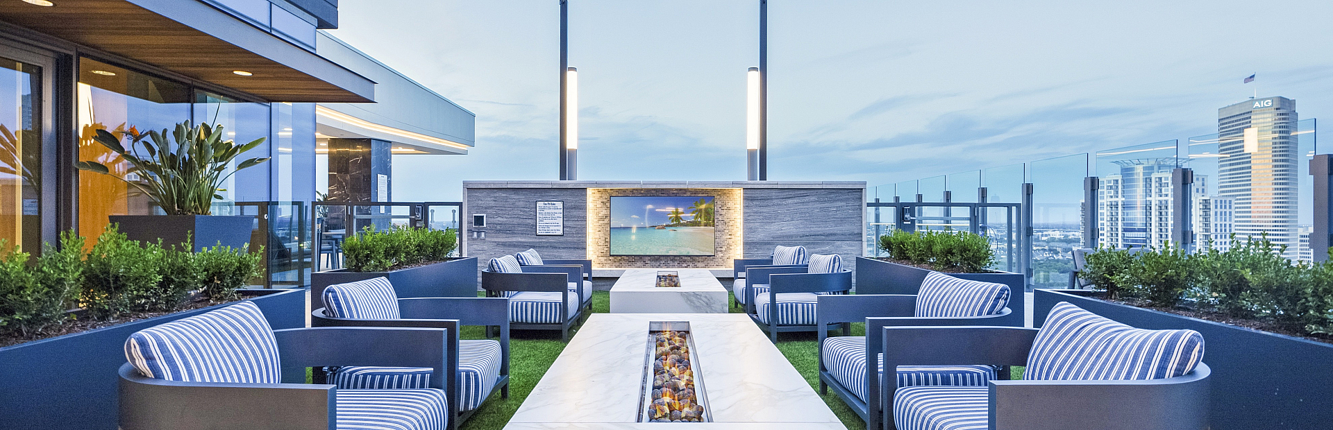 Luxurious rooftop terrace featuring stylish seating and ambient lighting with stunning city skyline views.