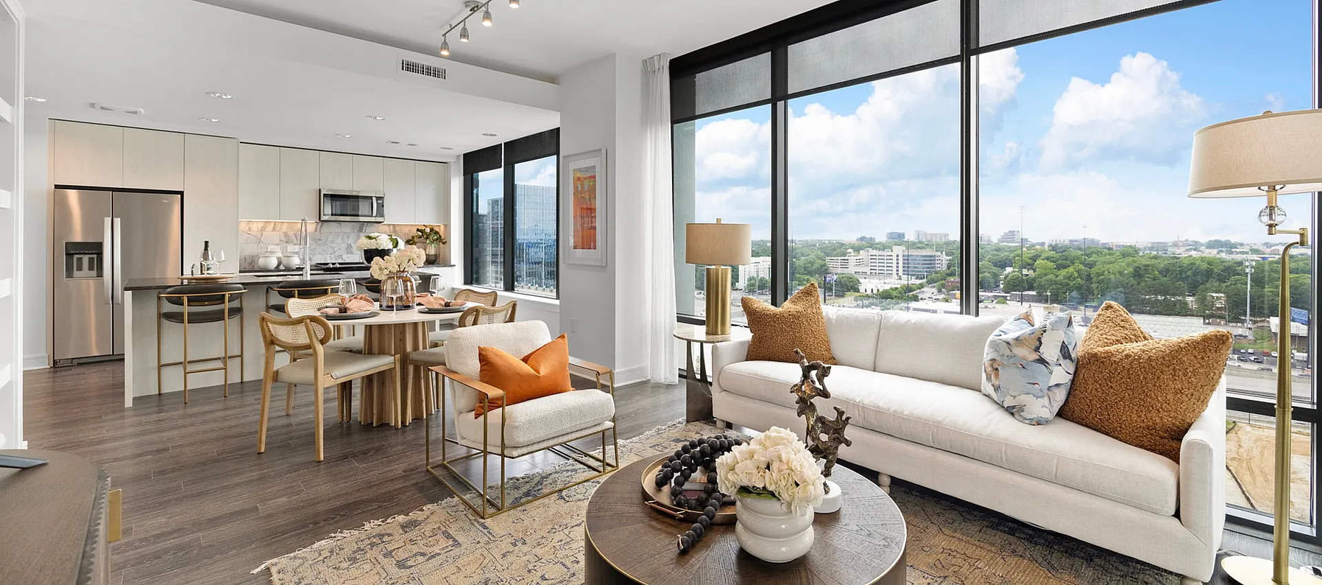 Luxurious open-concept living and dining area with modern kitchen, large windows offering stunning city views, and stylish decor.