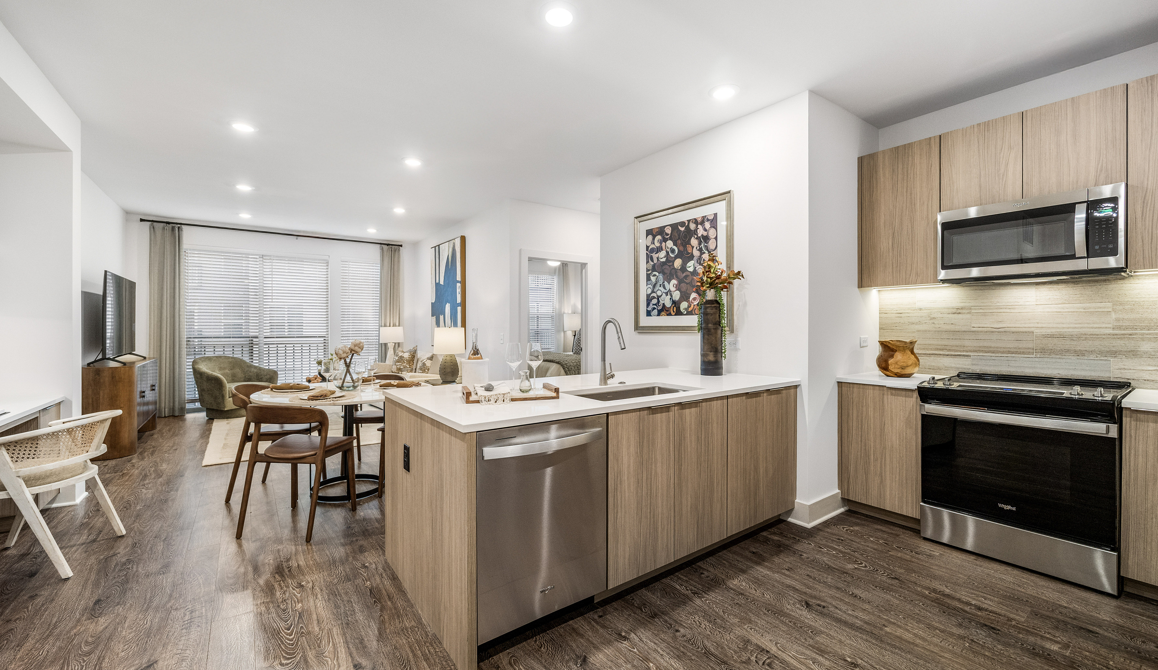 Modern open-concept kitchen and living area with sleek appliances, elegant wood flooring, and contemporary decor.