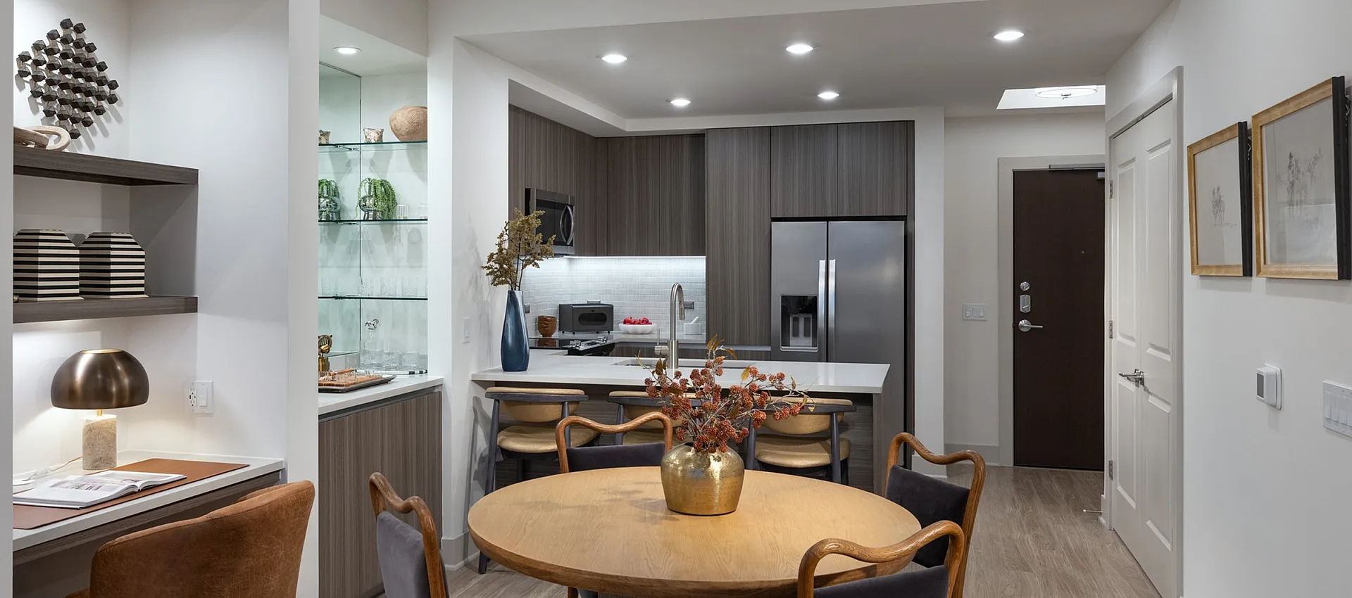 Chic open-concept kitchen and dining area with modern wood cabinets, luxurious finishes, and cozy seating, ideal for entertaining.