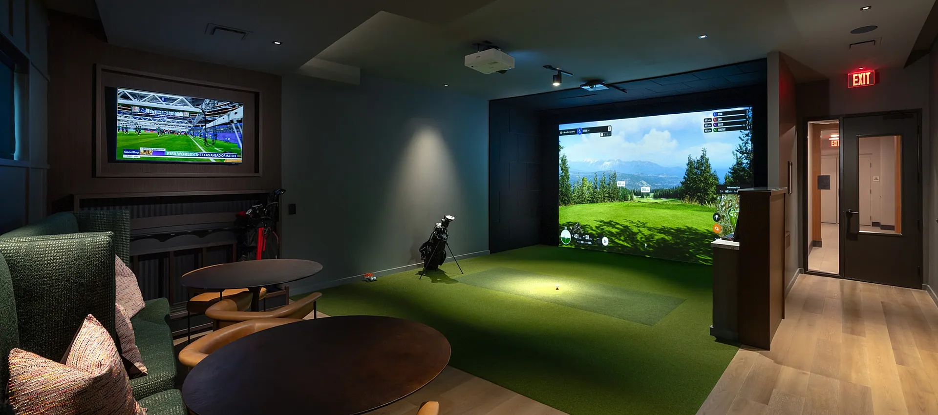 Luxurious indoor sports lounge featuring a golf simulator, comfortable seating area, and large screen TV for entertainment.