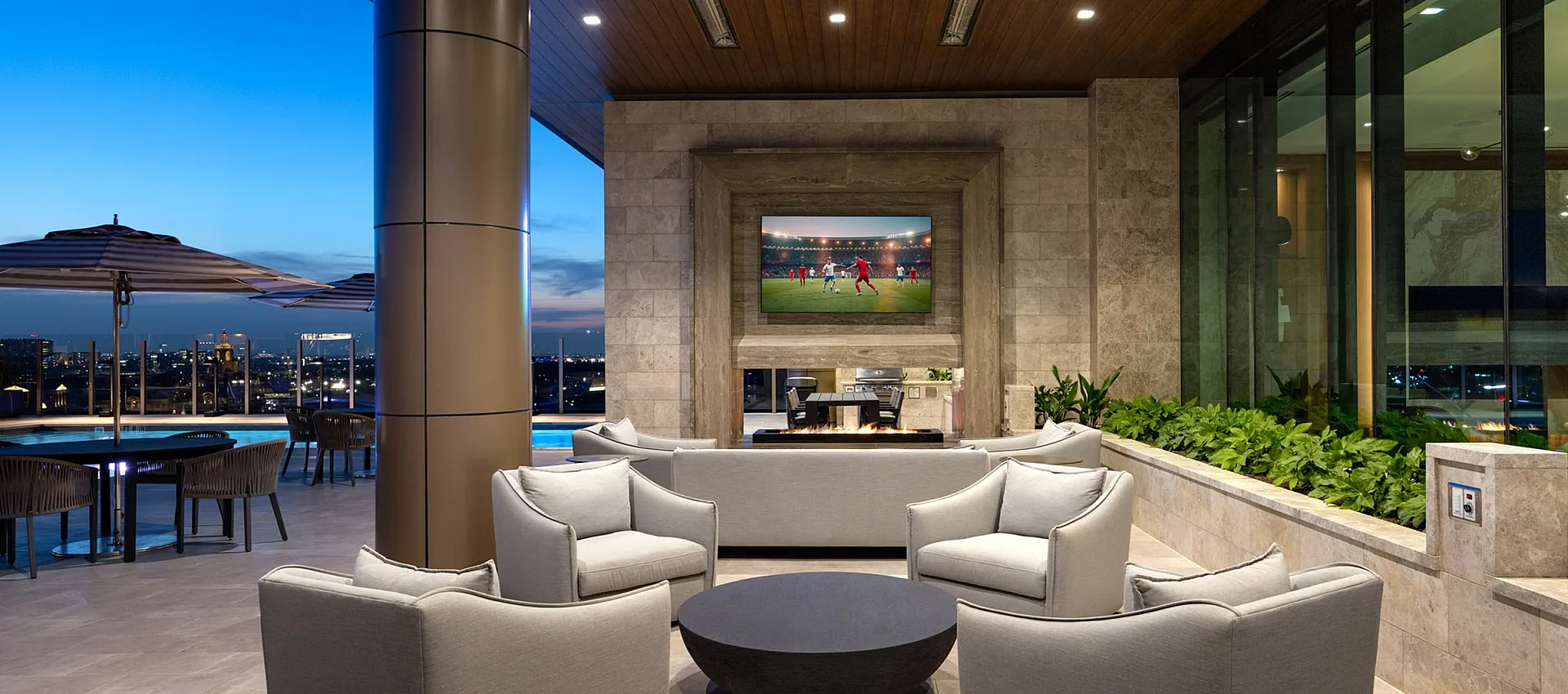 Luxurious rooftop lounge with modern seating, ambient lighting, and cityscape views, perfect for relaxation and entertainment.