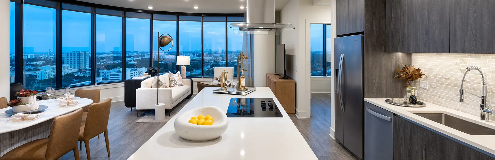 Luxurious open-concept apartment with panoramic city views, elegant kitchen, and stylish living area.