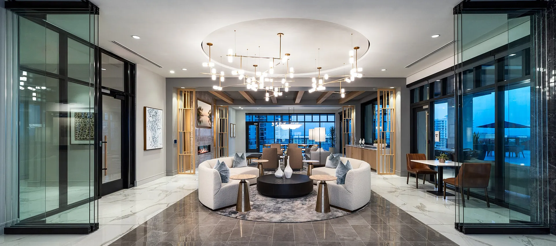 Luxurious modern lobby with elegant marble flooring, chic seating arrangement, and stunning chandelier lighting.