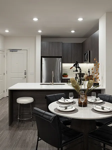 Contemporary apartment kitchen and dining area with sleek cabinetry, modern lighting, and elegant decor, perfect for stylish living.