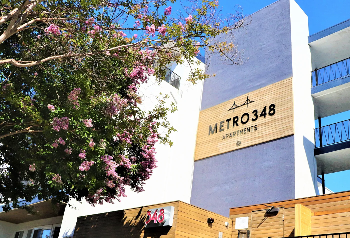 Modern Metro 348 Apartments exterior with vibrant landscaping and sleek architectural design.