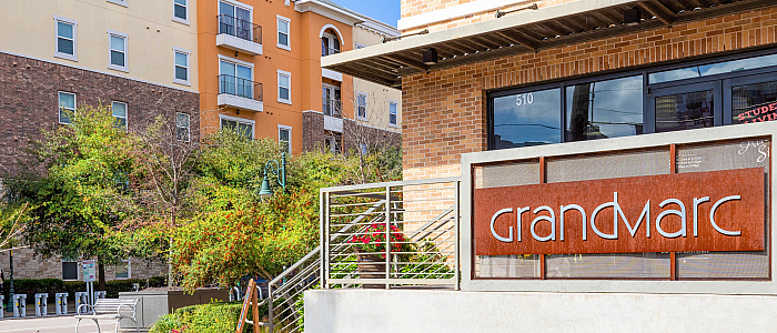 Inviting urban living at GrandMarc with modern architecture and lush landscaping, featuring a stylish exterior in a vibrant community setting.