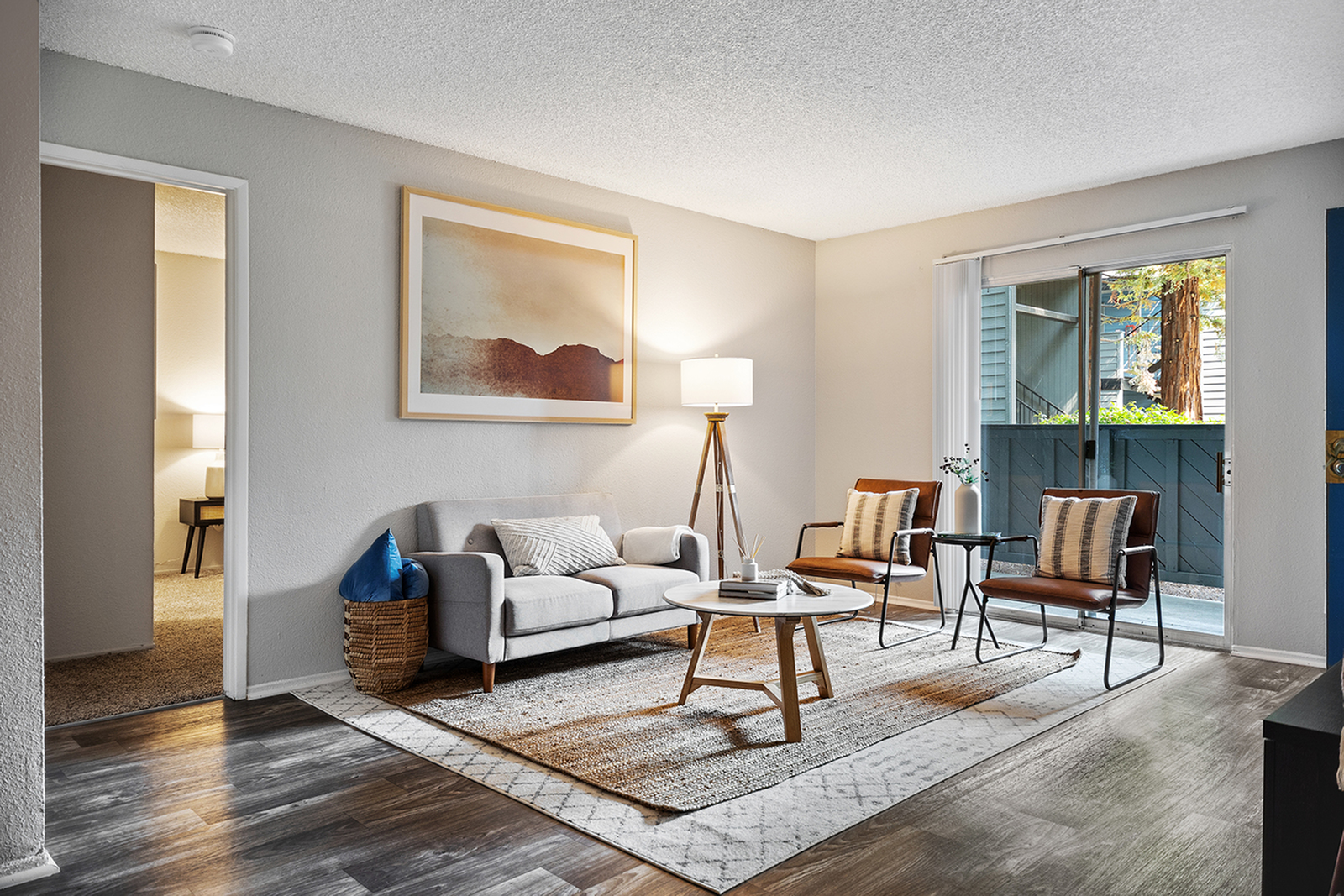 ReNew One59 bright living room with vinyl floors and sliding glass door leading to private patio