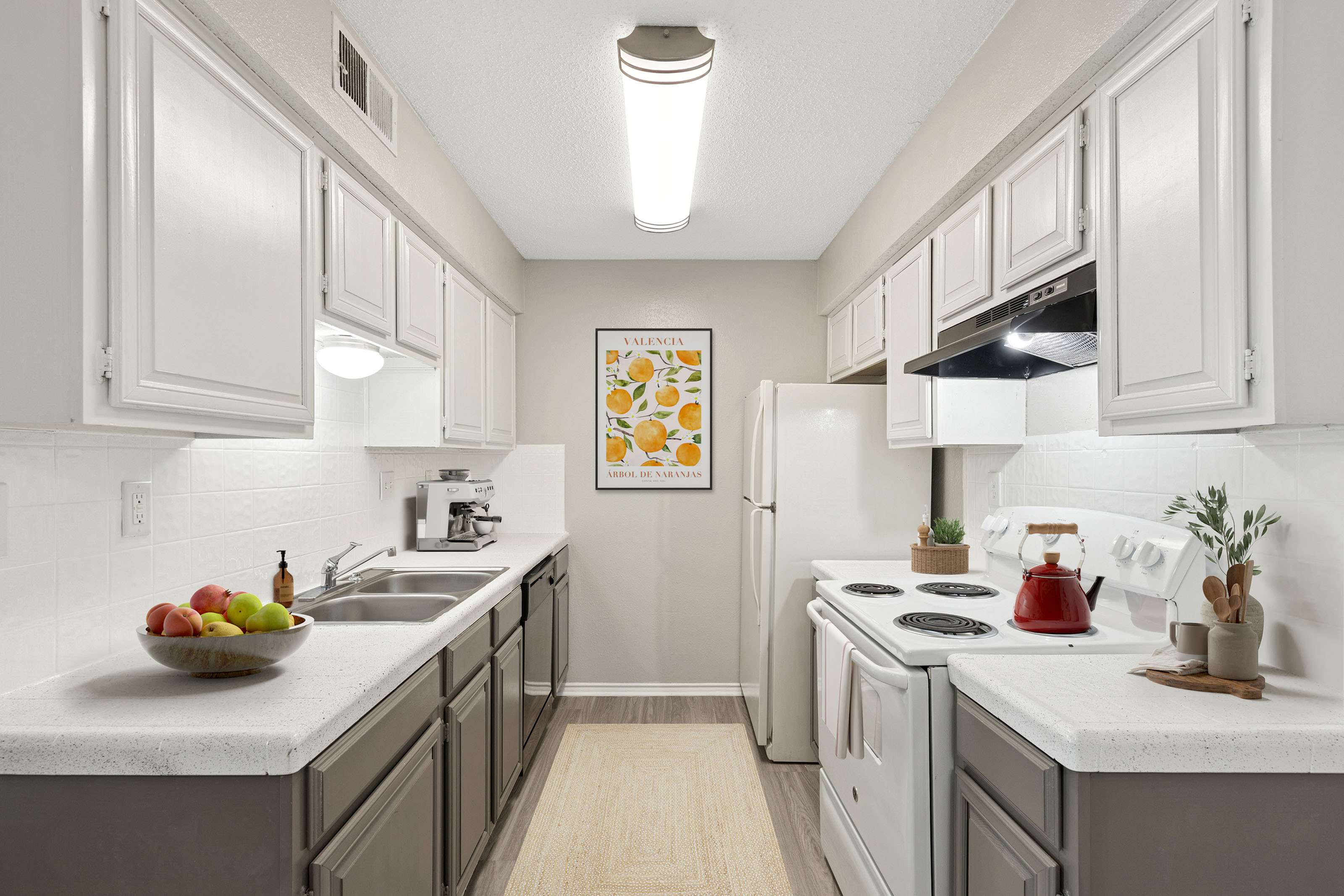 ReNew Holiday Hill bright kitchen with white appliances, red tea kettle on stove, and fruit bowl on counter