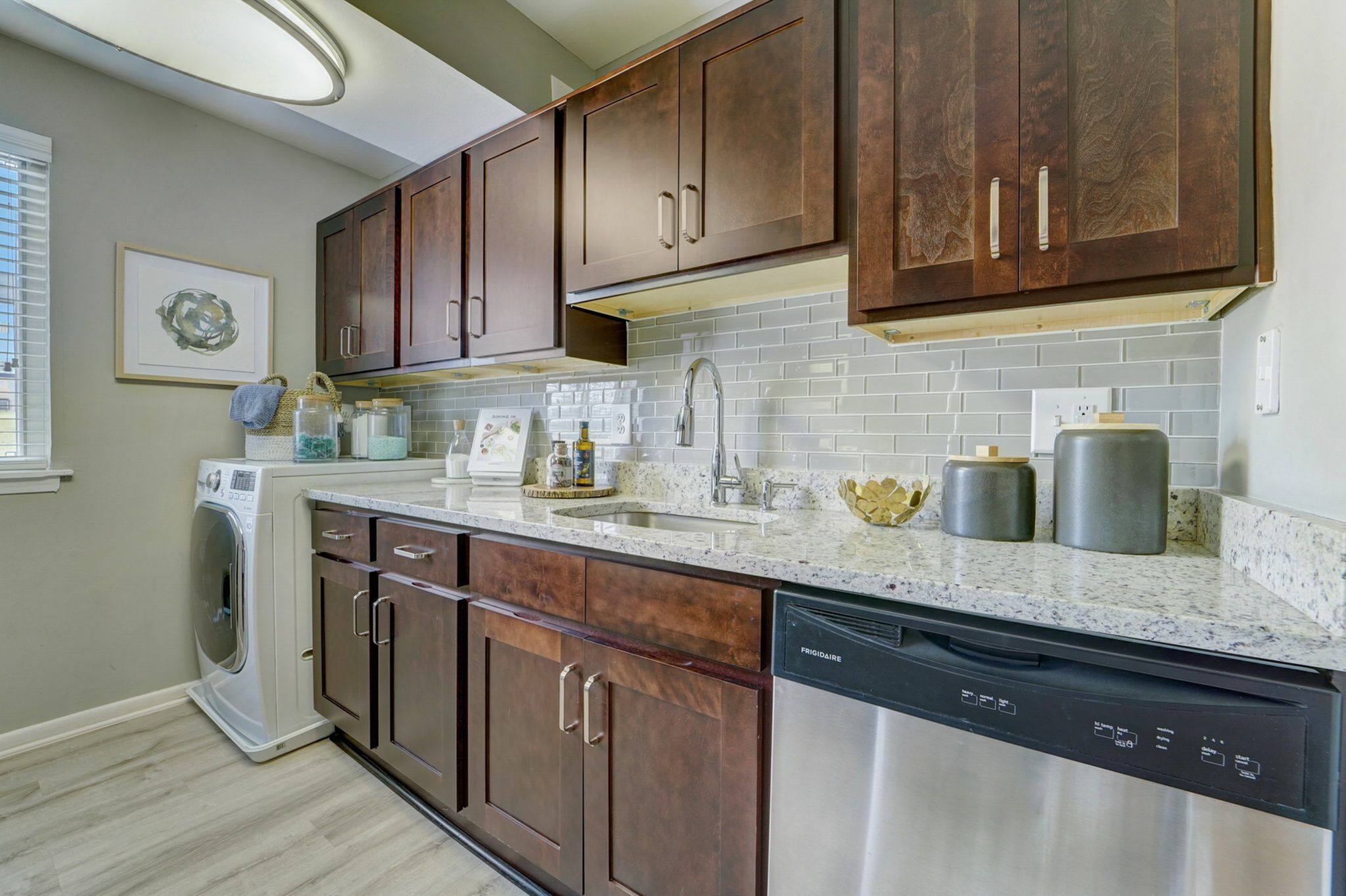 Renovated kitchen at ReNew White Marsh with lush cabinetry, quartz countertops, stainless steel appliances, and washer/dryer