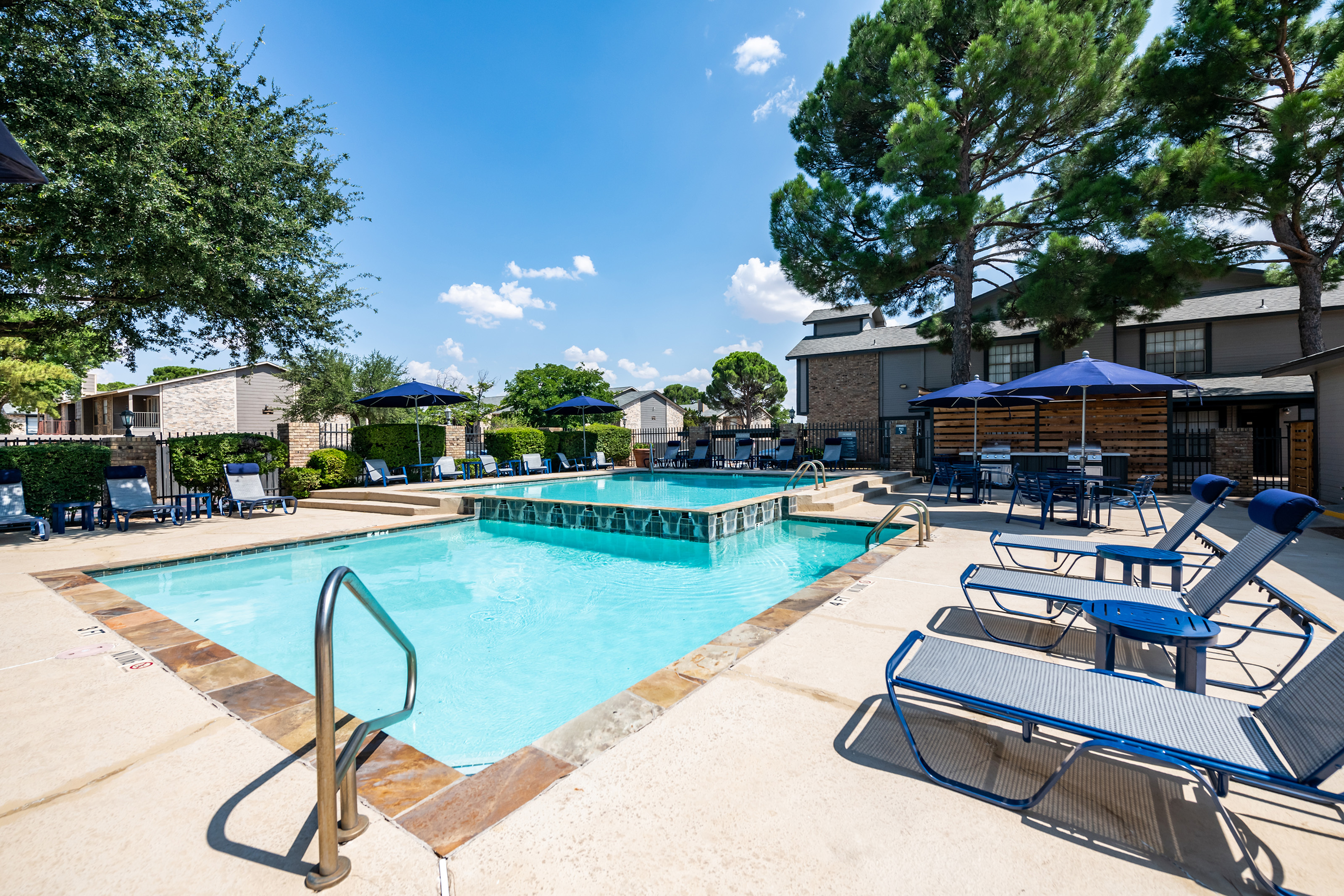 Sparkling swimming pool and spa at ReNew Holiday Hill surrounded by lush trees