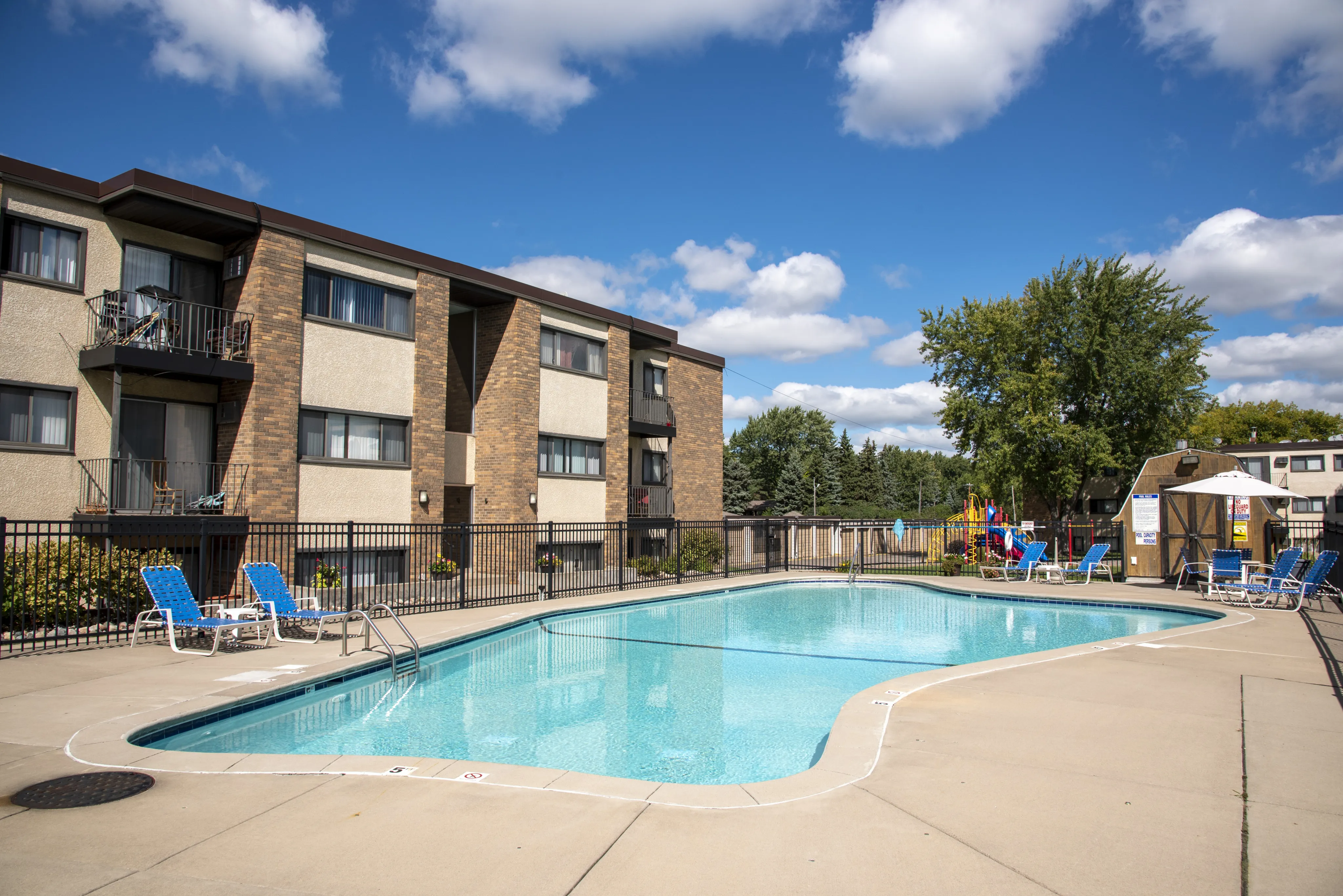 ReNew Meadow Lake vibrant colored playground with slide and climbing bars surrounded by trees